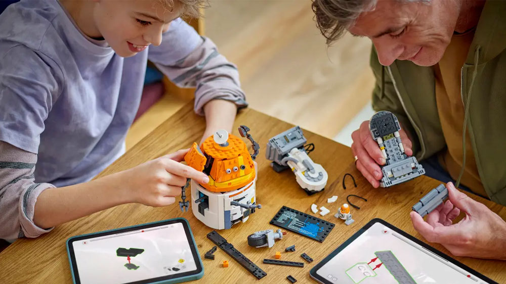 Muž se synem skládají stavebnici LEGO® Star Wars™ 75416 Astro-droid Chopper (C1-10P) s pomocí aplikace LEGO® Builder na tabletu_04