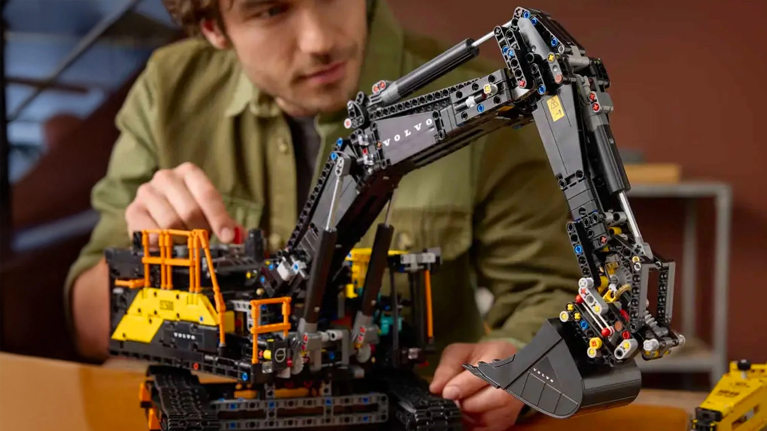 Muž pohybuje s bagrem ze stavebnice LEGO® Technic 42215 Bagr Volvo EC500 Hybrid.