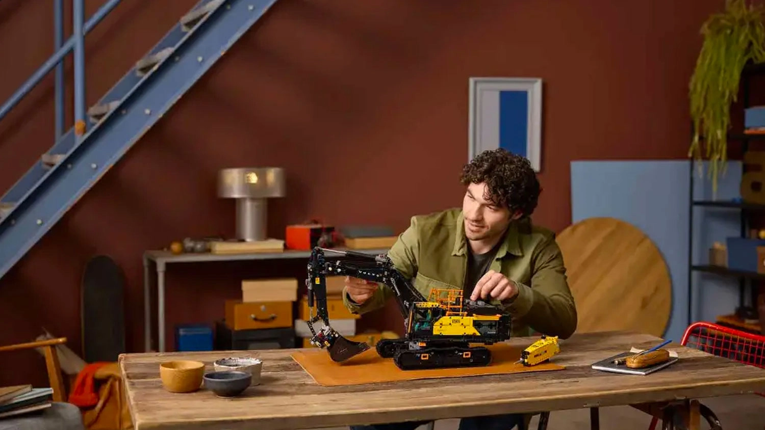 Muž se stavebnicí LEGO® Technic 42215 Bagr Volvo EC500 Hybrid.