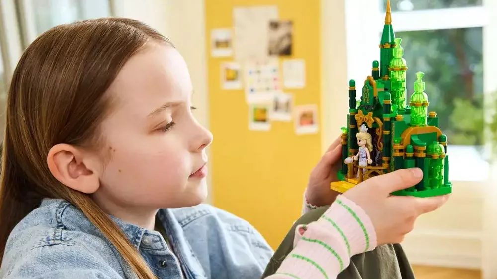 Dievča drží v ruke zostavený model stavebnice LEGO® 75689 Emerald City a zámok Kiamo Ko_03