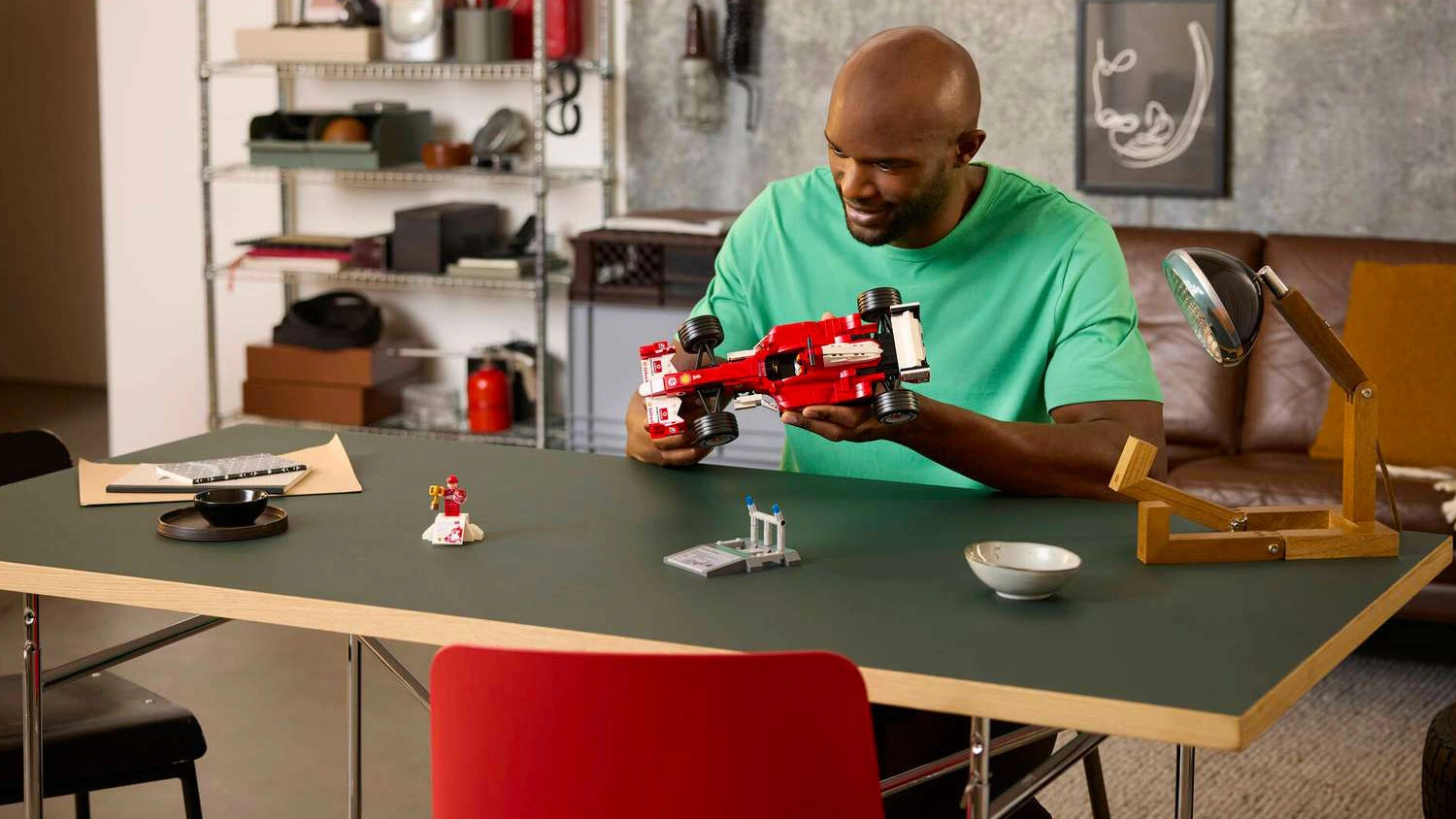 Muž obdivuje model vozu ze stavebnice LEGO® Icons 11375 Ferrari F2004 a Michael Schumacher
