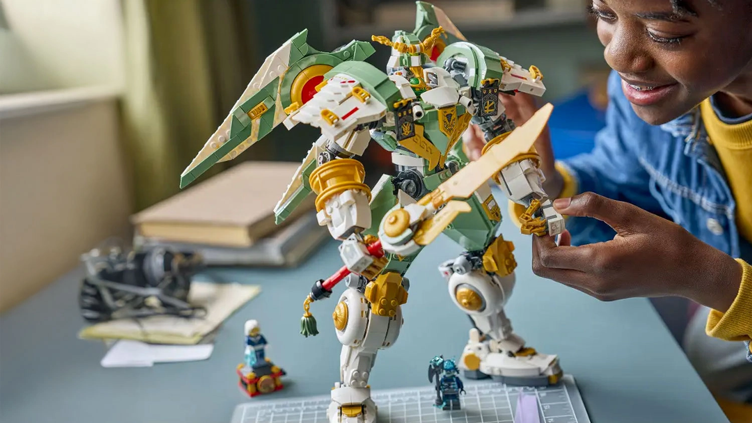 Usmívající se chlapec si hraje s titanovým robotem ze stavebnice LEGO® NINJAGO® (71860)