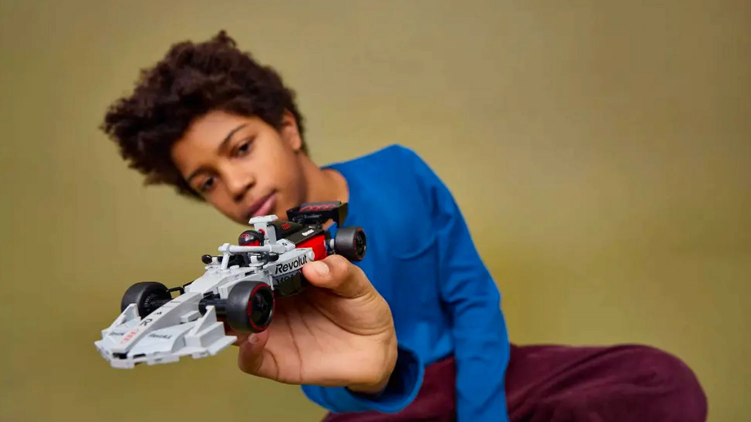 Chlapec si prohl&iacute;ž&iacute; z&aacute;vodn&iacute; auto Audi Revolut F1 Team R26 ze stavebnice LEGO&reg; Speed Champions (77259)