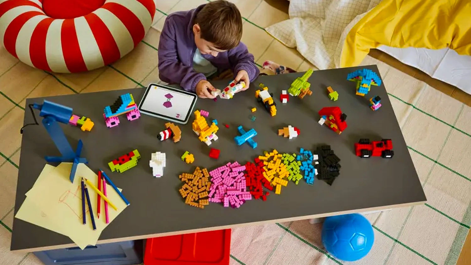 Chlapec má na stole kocky LEGO® Classic a stavia podľa návodu