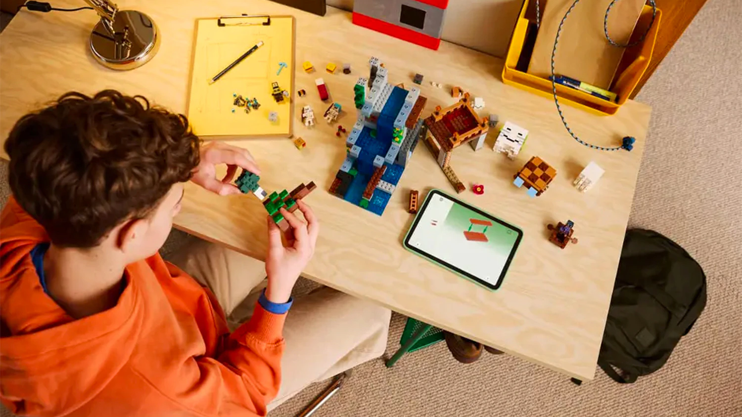 Chlapec skládá stavebnici LEGO® za asistence aplikace na tabletu
