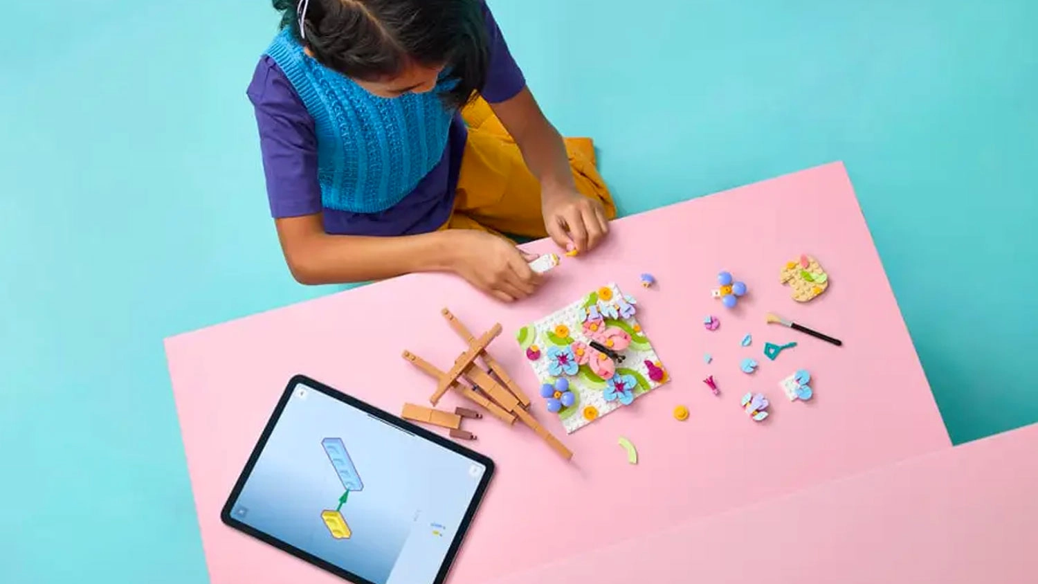 Děvče staví LEGO® Creator 3 v 1 31390 Květinová malba pomocí aplikace