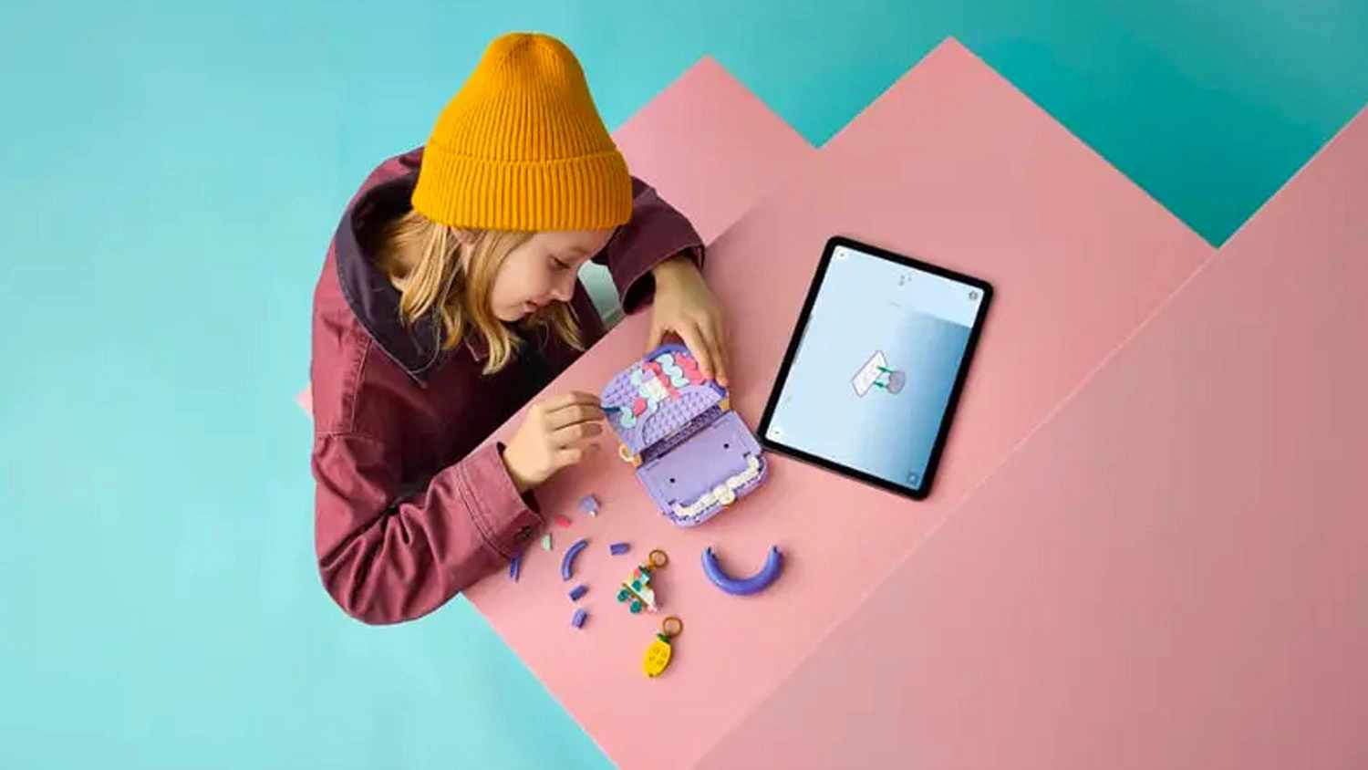Dievča stavia LEGO&reg; Creator 3 v 1 31391 M&oacute;dna kabelka s &uacute;ložn&yacute;m priestorom pomocou aplik&aacute;cie
