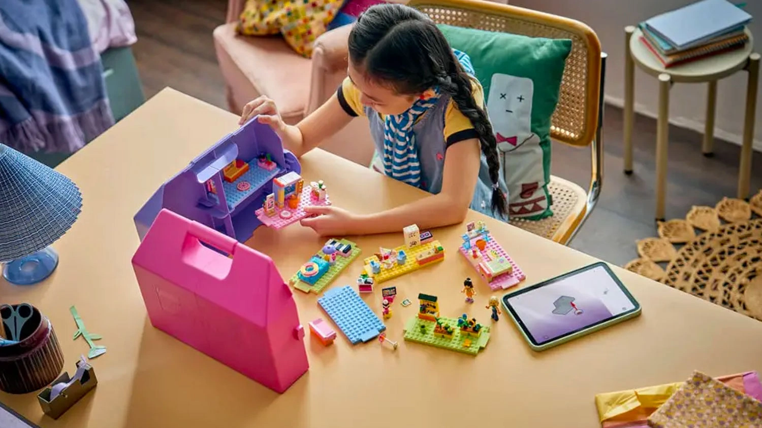 Holčička staví kostky LEGO® Friends 42697 Kreativní kufřík a domek pro panenky