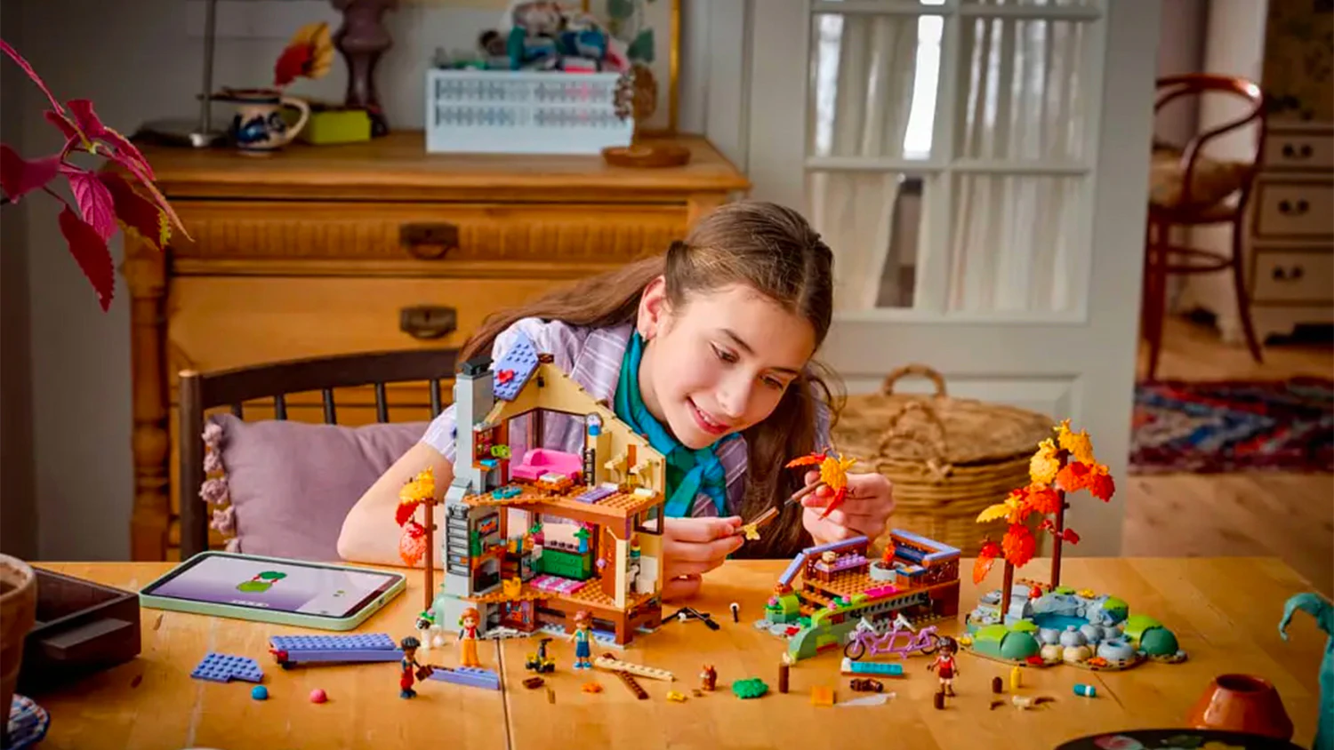 Děvče skládá stavebnici LEGO® u stolu