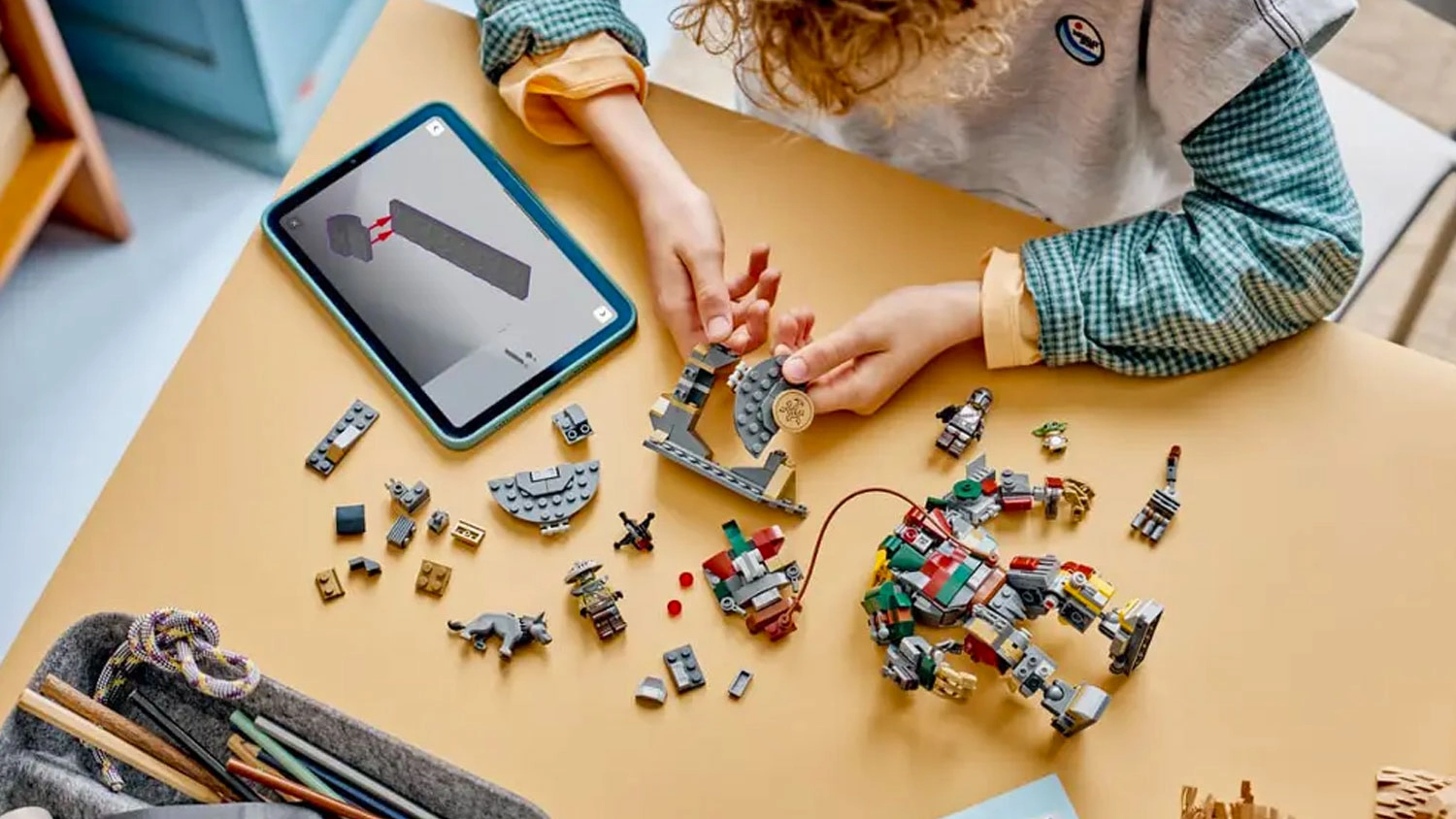 Chlapec zostavuje podľa aplik&aacute;cie LEGO&reg; Builder kocky LEGO&reg; Star Wars&trade; 75451 S&uacute;boj s ochrank&aacute;rom droidom v pal&aacute;ci Hutta