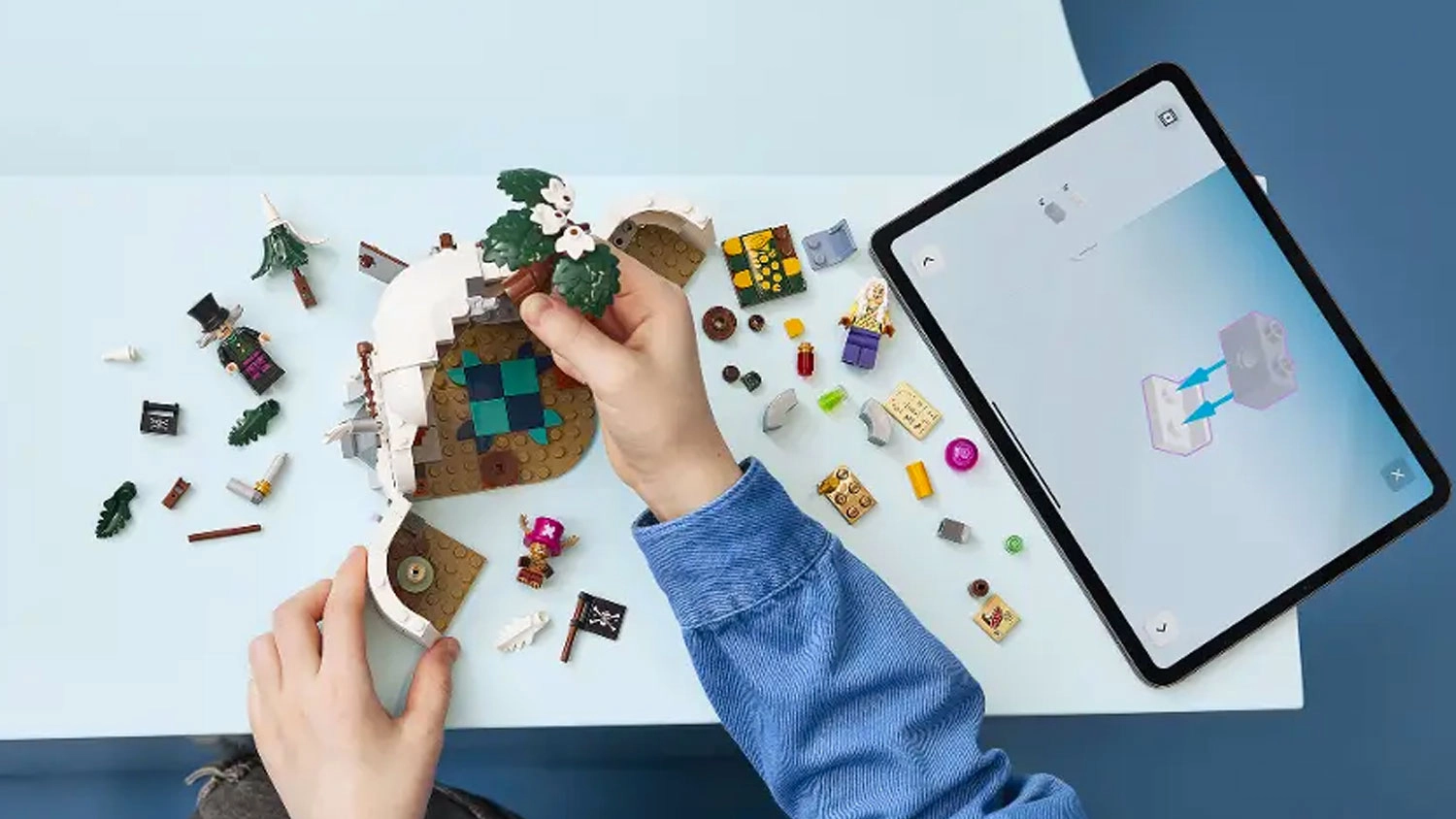 Chlapec stavia pomocou aplikácie LEGO® Builder kocky LEGO® ONE PIECE 75641 Úkryt Dr. Hiriluka