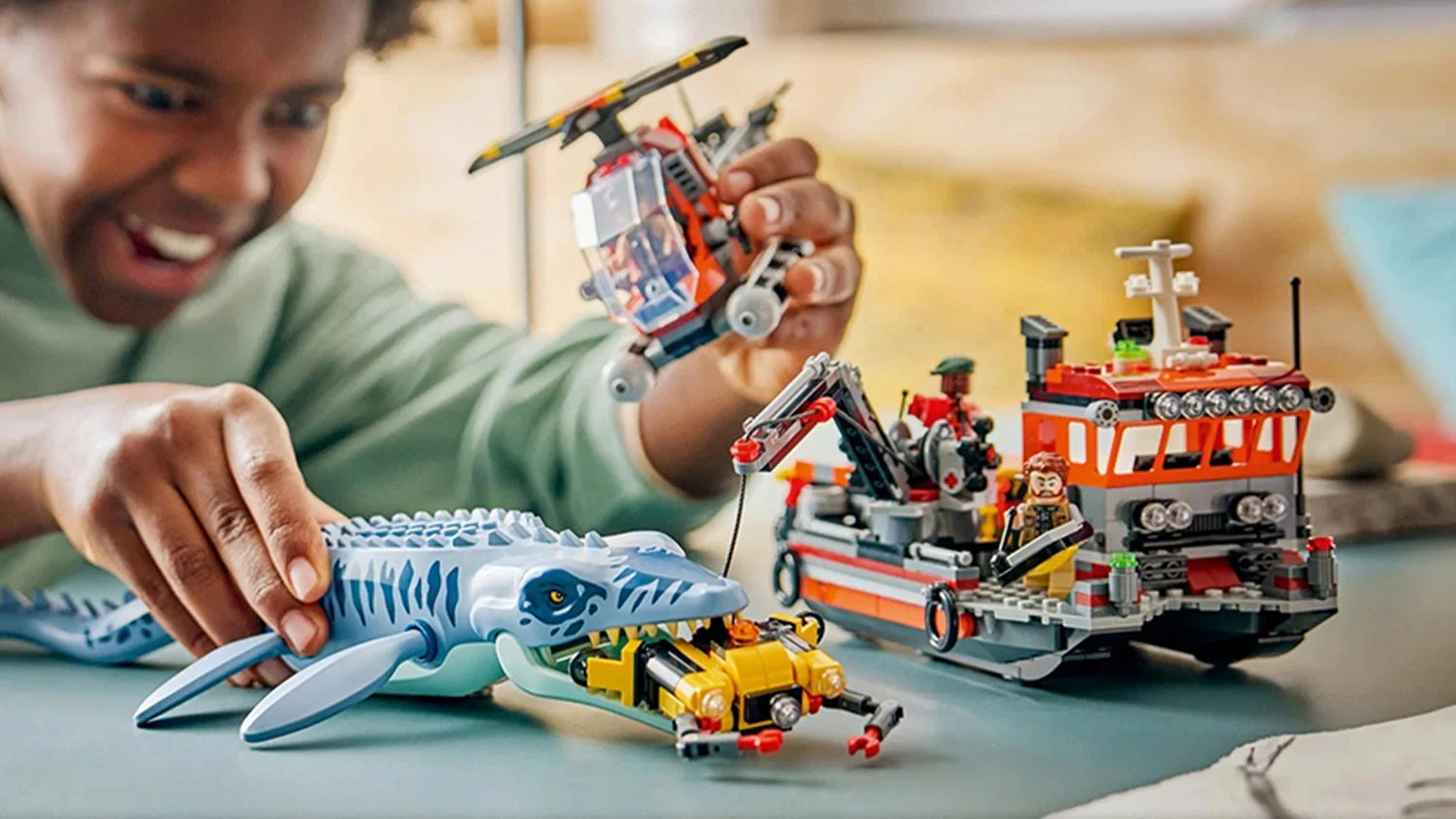 Chlapec při dobrodružstv&iacute; se stavebnic&iacute; LEGO&reg; Jurassic World 77983 &Uacute;tok dinosaura mosasaura na loď