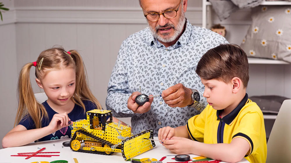 Muž si hraje s dětmi se stavebnicí Merkur_02