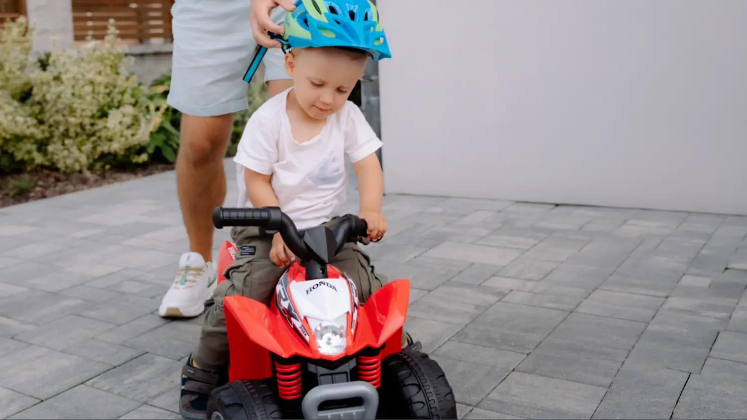 Chlapeček s helmou sed&iacute; na čtyřkolce Honda