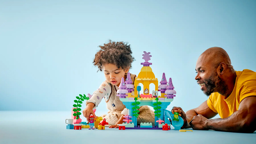 Otec s dítětem u stavebnice LEGO® DUPLO® Disney Arielin kouzelný podmořský palác 10435 EW_02