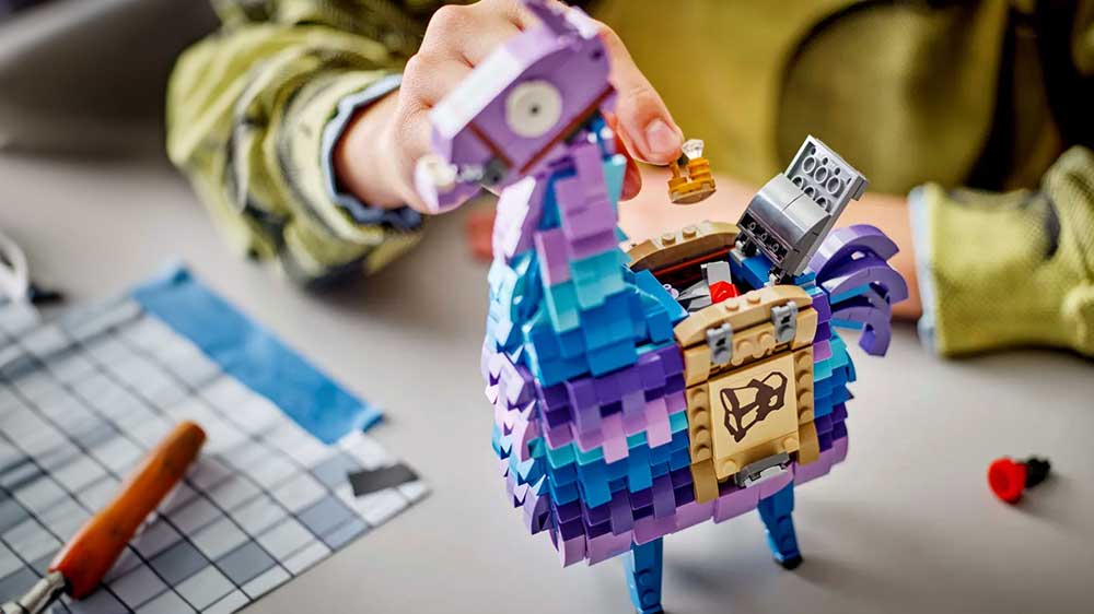 Chlapec si hraje s LEGO® Fortnite® 77071 Supply Llama a schovává doplňky pod poklop na zádech lamy_02