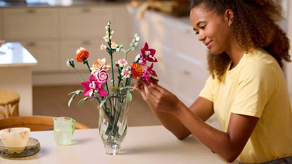 Žena staví stavebnici LEGO® Botanicals 10342 Krásná kytice růžových květin_02