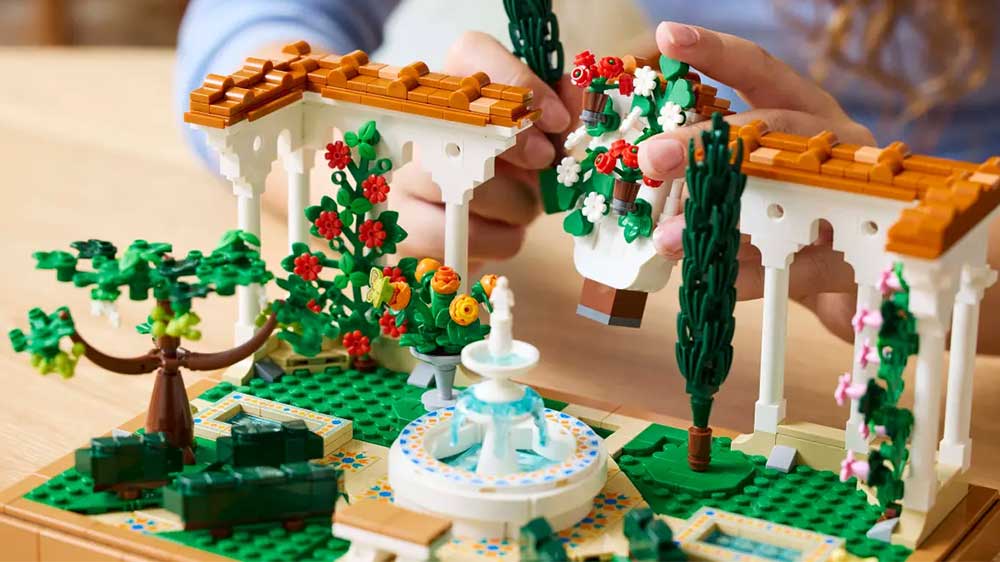 Žena sestavuje stavebnici LEGO® Icons 10359 Zahrada s fontánou_02
