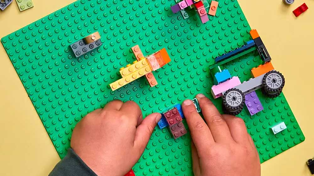 Stavebnice LEGO® Classic 11023 Zelená podložka na stavění pohled na stavějící dětské ruce_02