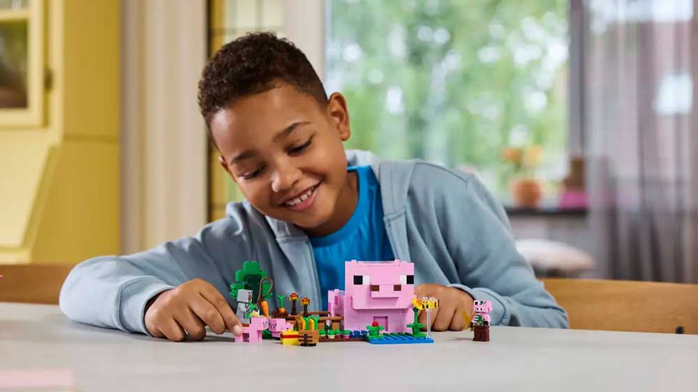 Chlapec si hraje se Stavebnicí LEGO® Minecraft® 21268 Domeček Prasátka_02