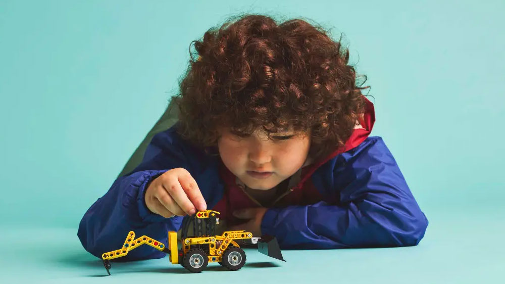 Chlapec si hraje se stavebnicí LEGO® Technic 42197 Zadní nakladač_03