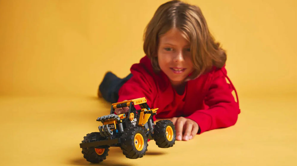 Chlapec si s úsměvem hraje s LEGO® Technic 42199 Monster Jam™ DIGatron™ s natahovacím motorem_03
