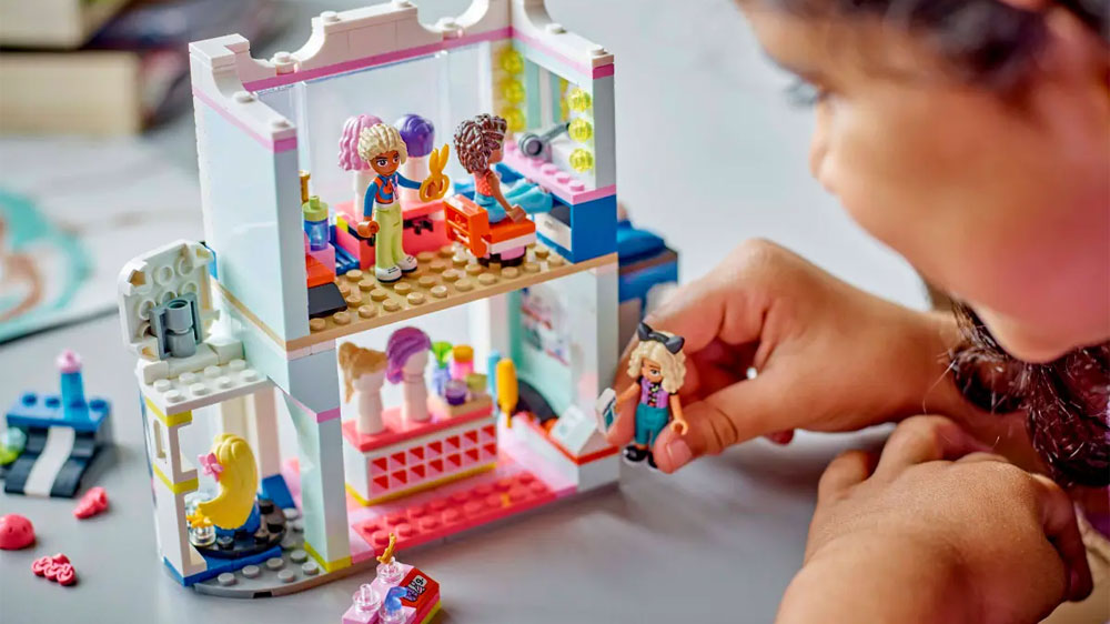 Holčička hrající si se stavebnicí LEGO® Friends 42662 Kadeřnictví a obchod s doplňky _03