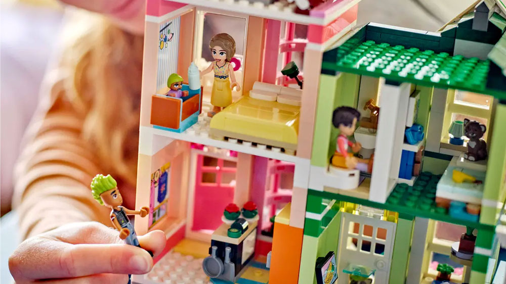 Holčička hrající si se stavebnicí LEGO® Friends 42670 Apartmány a obchody v městečku Heartlake _03