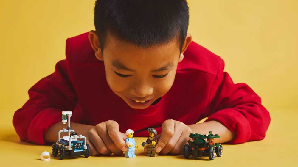 Chlapec si hraje se stavebnicí LEGO® City 60459 Závodní balíček: Letadlo vs. nemocniční lůžko_03