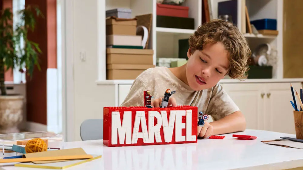 Chlapec si hraje se Stavebnicí LEGO® Marvel 76313 Logo MARVEL a minifigurky_02