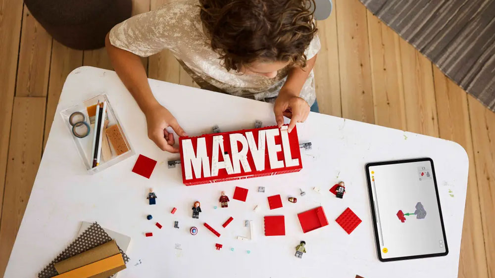 Chlapec si hraje se Stavebnicí LEGO® Marvel 76313 Logo MARVEL a minifigurky_04