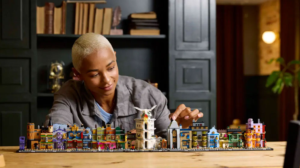 Žena staví stavebnici LEGO® Harry Potter™ 76444 Kouzelnické obchody v Příčné ulici_02