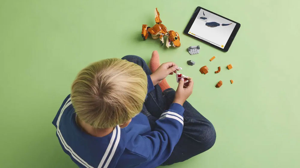 Chlapec staví podle aplikace LEGO® Builder stavebnici LEGO® Jurassic World 76967 Malá Žravka: T-rex _04