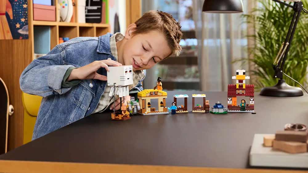 Chlapec hrající si se stavebnicí LEGO® Minecraft 21273 Balón v podobě ďasa a útok na vesnici_02