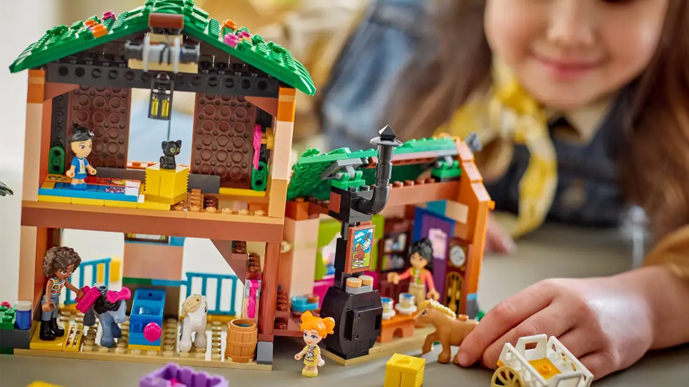 Usmívající se dívka si hraje se stavebnicí® LEGO Friends a drží v ruce figurku poníka_02