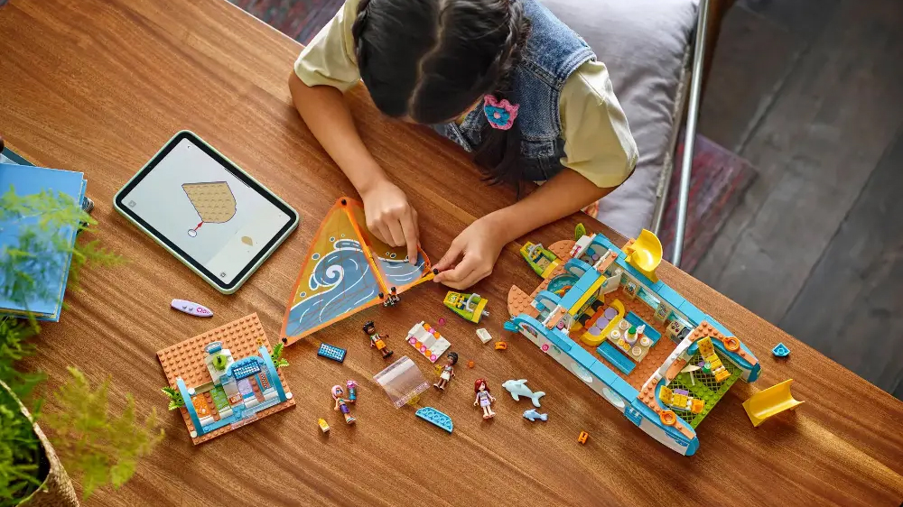 Dívka sestavuje stavebnici Dobrodružství na jachtě s pomocí aplikace LEGO® Builder v tabletu_04