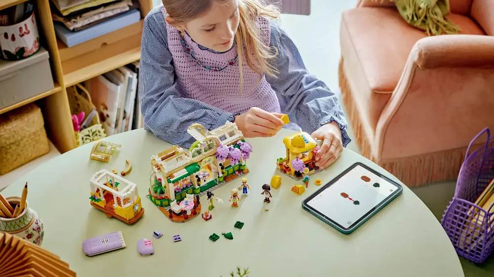 Dívka sestavuje stavebnici LEGO® Friends 42671 Kavárna plná rostlin a květinářství s pomocí aplikace LEGO® Builder v tabletu_04