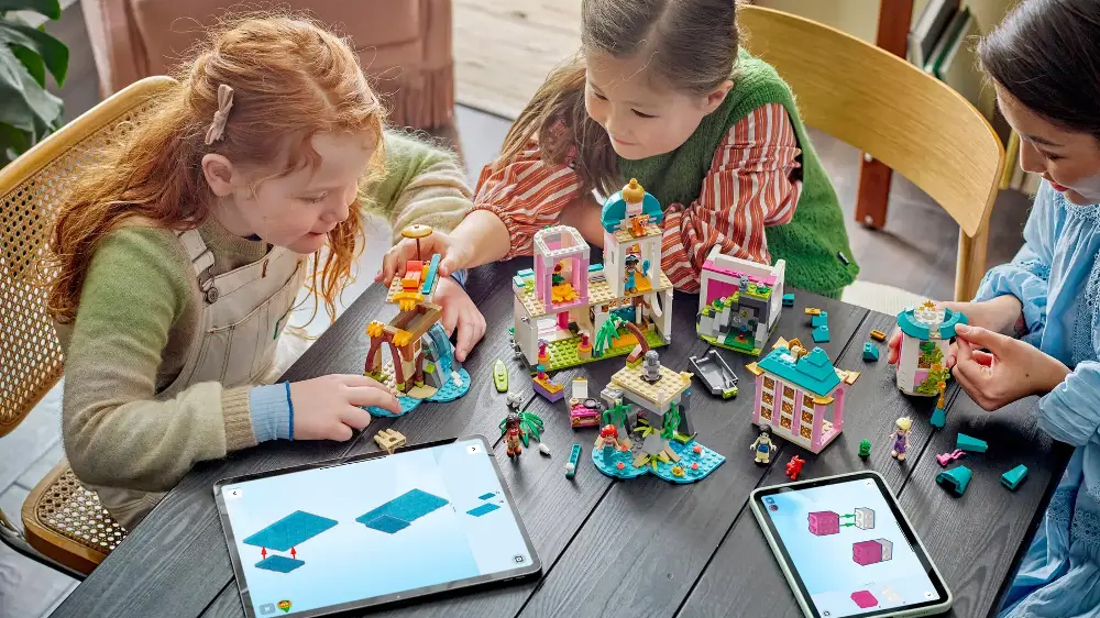 Dospělá žena staví s dětmi stavebnici LEGO® Disney 43267 Hrad princezen a královští domácí mazlíčci s pomocí aplikace LEGO® Builder v tabletu_04