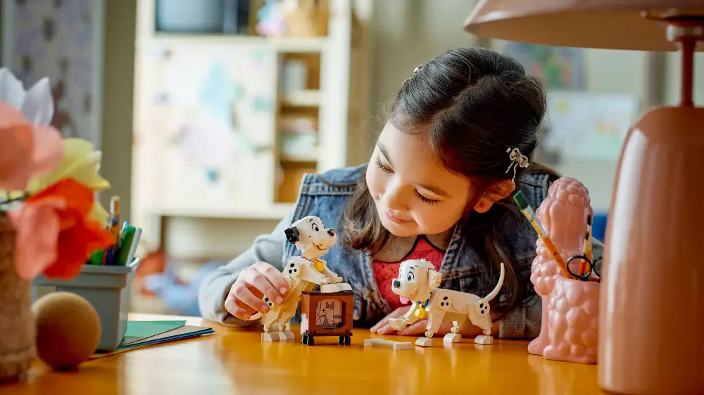 Holčička si hraje se &scaron;těň&aacute;tky dalmatinů ze stavebnice LEGO&reg; DISNEY a měn&iacute; jejich polohy_02