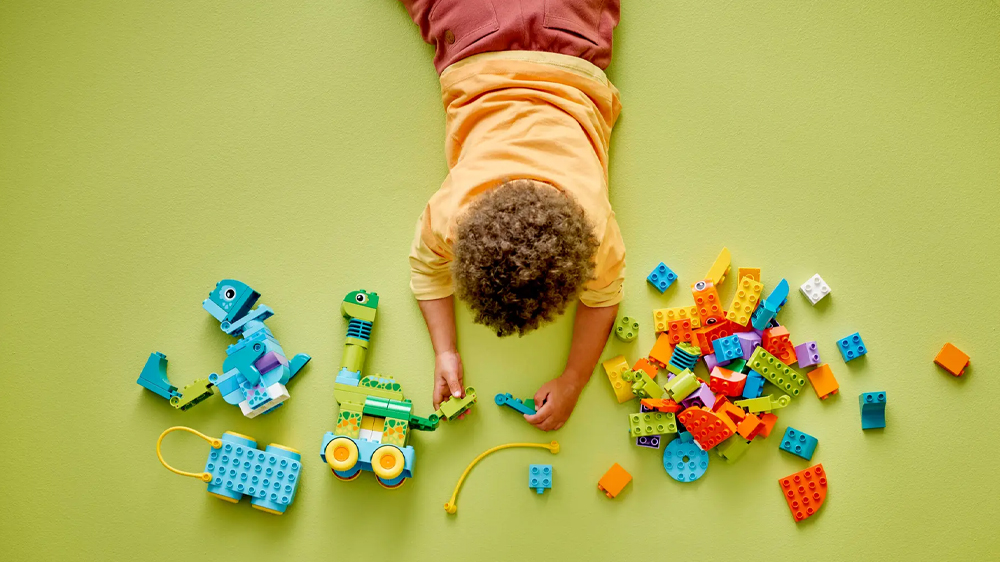 Chlapec sestavuje stavebnici LEGO® DUPLO® 3v1: Dinosauři na kolečkách_03
