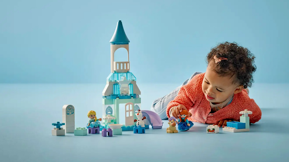 Holčička si hraje s princeznou ze stavebnice LEGO® DUPLO® Disney 10455 Ledové království: Anna a Elsa a oslava na hradě_04