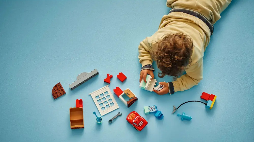 Mal&yacute; chlapec sestavuje stavebnici LEGO&reg; DUPLO&reg; Disney 10456 McQueen a n&aacute;v&scaron;těva v gar&aacute;ži doktora Hudsona_02