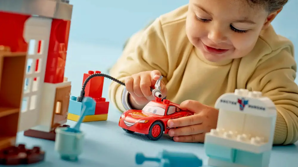 Mal&yacute; chlapec um&yacute;v&aacute; z&aacute;vodn&iacute; aut&iacute;čko Bleska McQueena pomoc&iacute; sestaven&eacute; automyčky_03