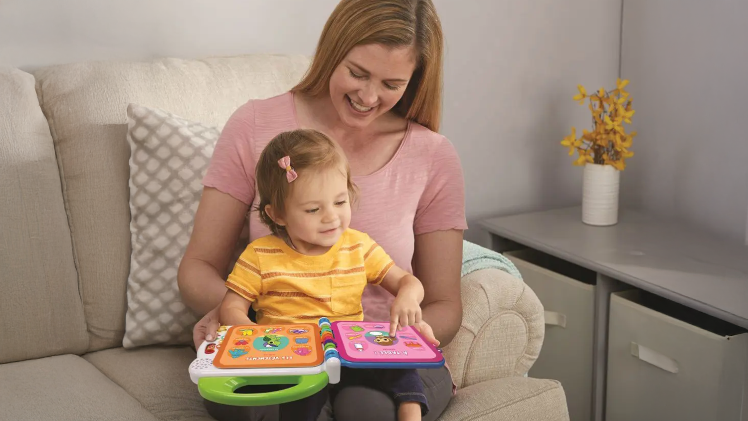 D&iacute;tě sed&iacute;c&iacute; ženě na kl&iacute;ně si hraje s kn&iacute;žkou se zvuky Vtech M&yacute;ch 100 slov&iacute;ček_03