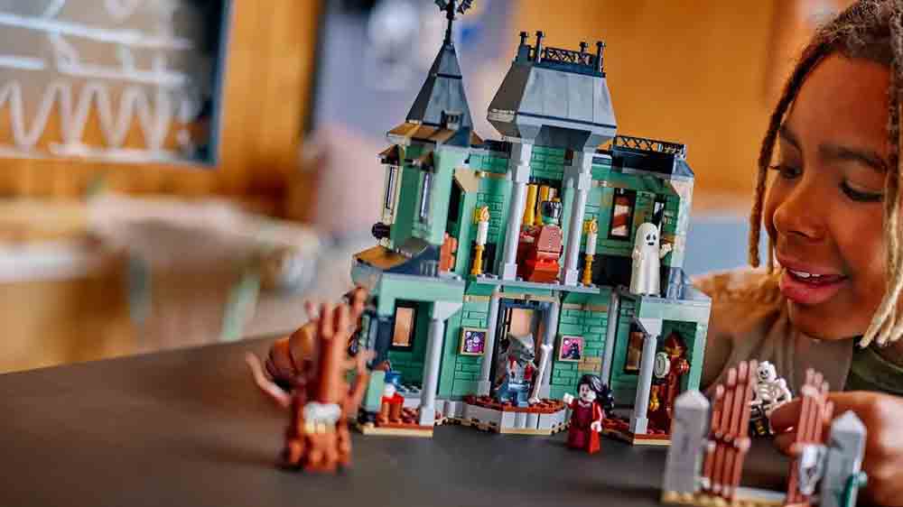 Dívka si hraje s modelem strašidelného domu a minifigurkami ze stavebnice LEGO® Creator 3 v 1 31167_03
