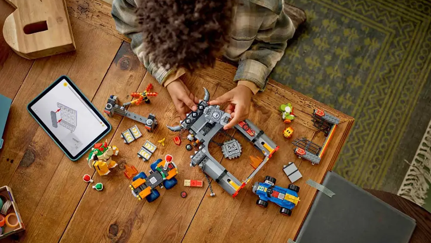 Chlapec sestavuje stavebnici LEGO® Super Mario™ 72039 Mario Kart™ – Bowser a jeho hrad s pomocí aplikace LEGO® Builder v tabletu_04