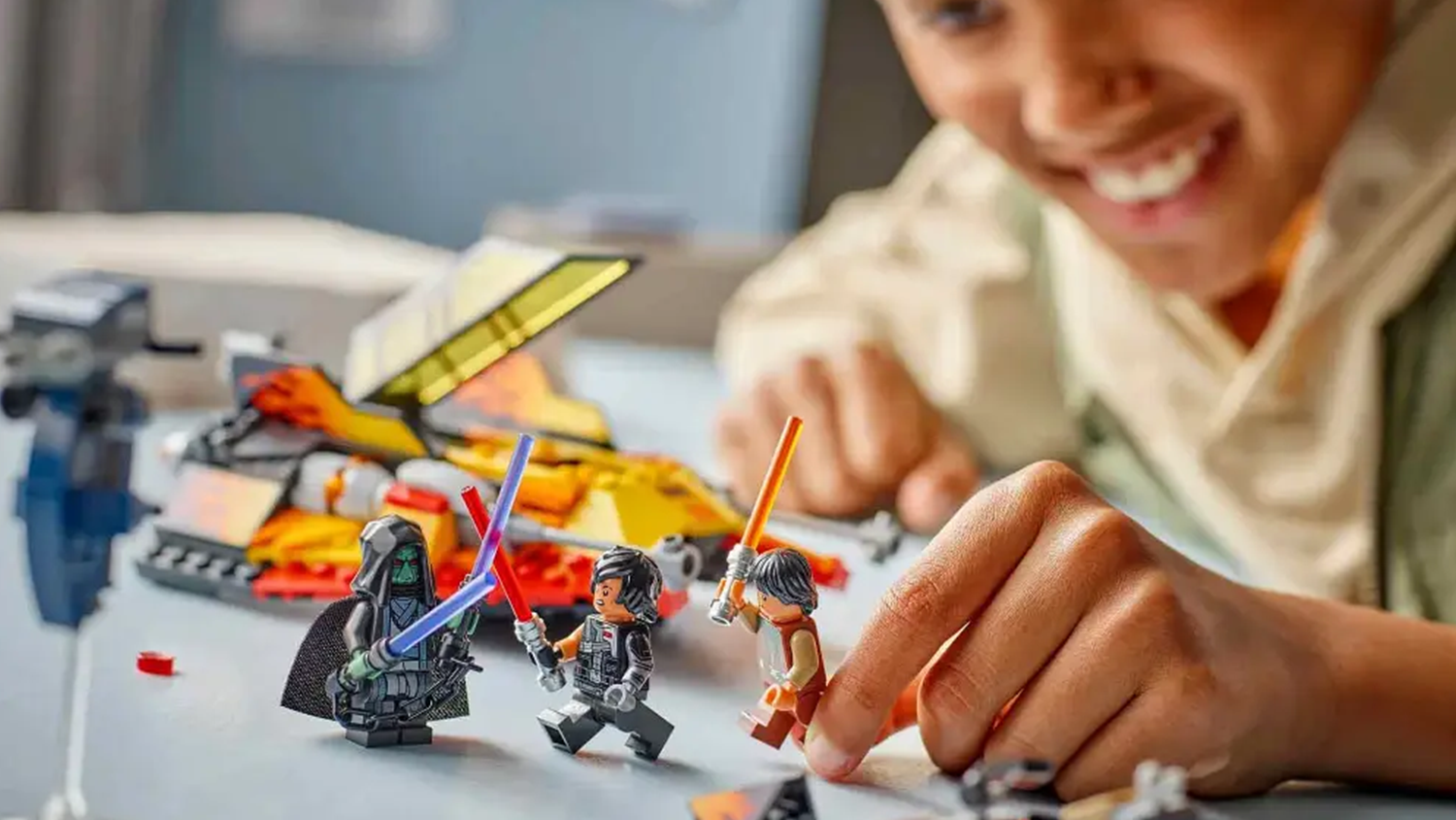 Usmievajúci sa chlapec sa hrá s minifigúrkami so svetelnými mečmi zo stavebnice LEGO® Star Wars™ 75414 Snežný spíder Force Burner_03