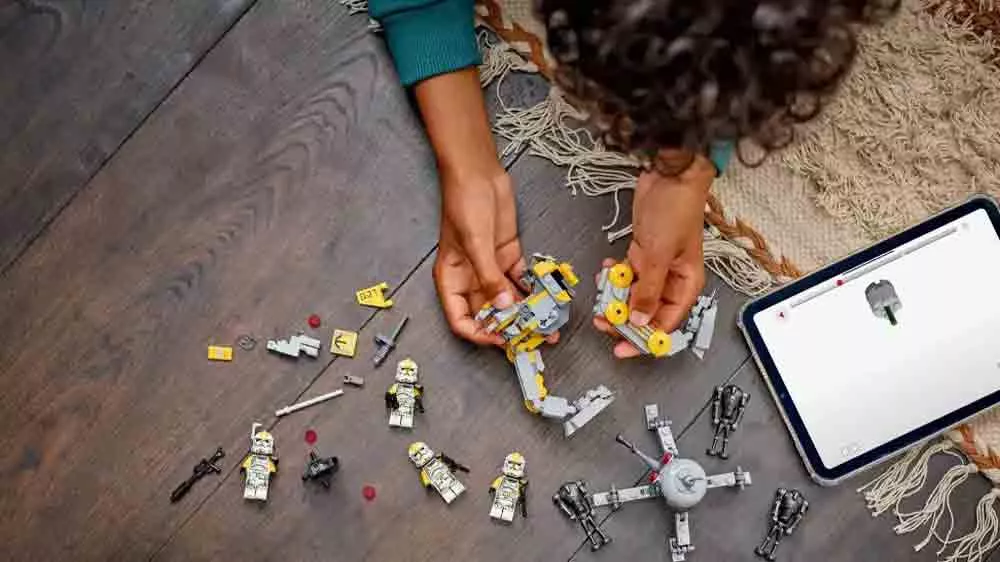 Dieťa stavia stavebnicu LEGO® Star Wars™ 75431 bojový balík klonovaných vojakov z 327. hviezdneho zboru s pokynmi v aplikácii v tablete_04
