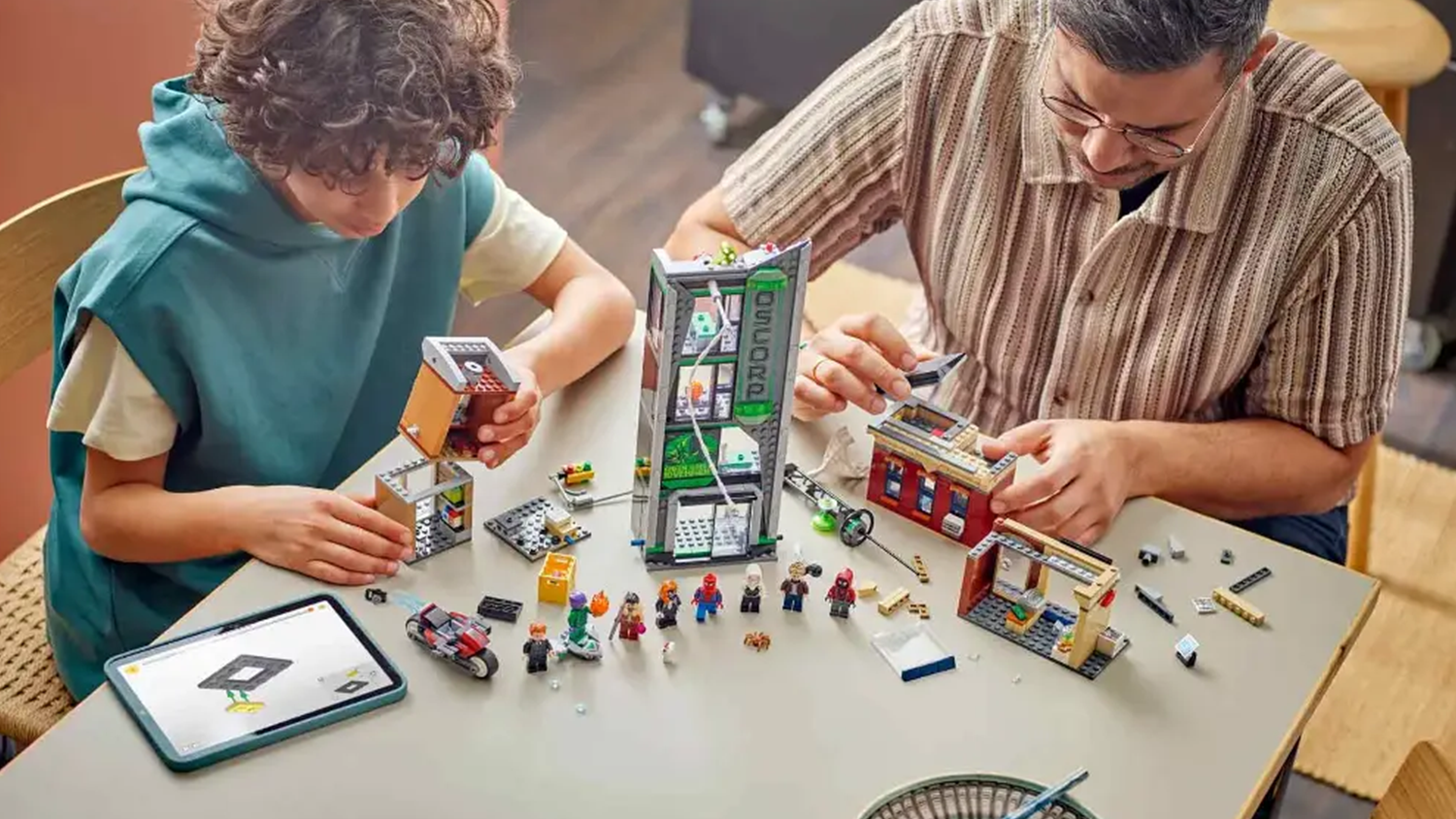 Muž s chlapcem sestavuj&iacute; stavebnici LEGO&reg;  Marvel 76324 Spider-Man vs. Oscorp s pomoc&iacute; n&aacute;vodu v aplikaci LEGO&reg; Builder_04