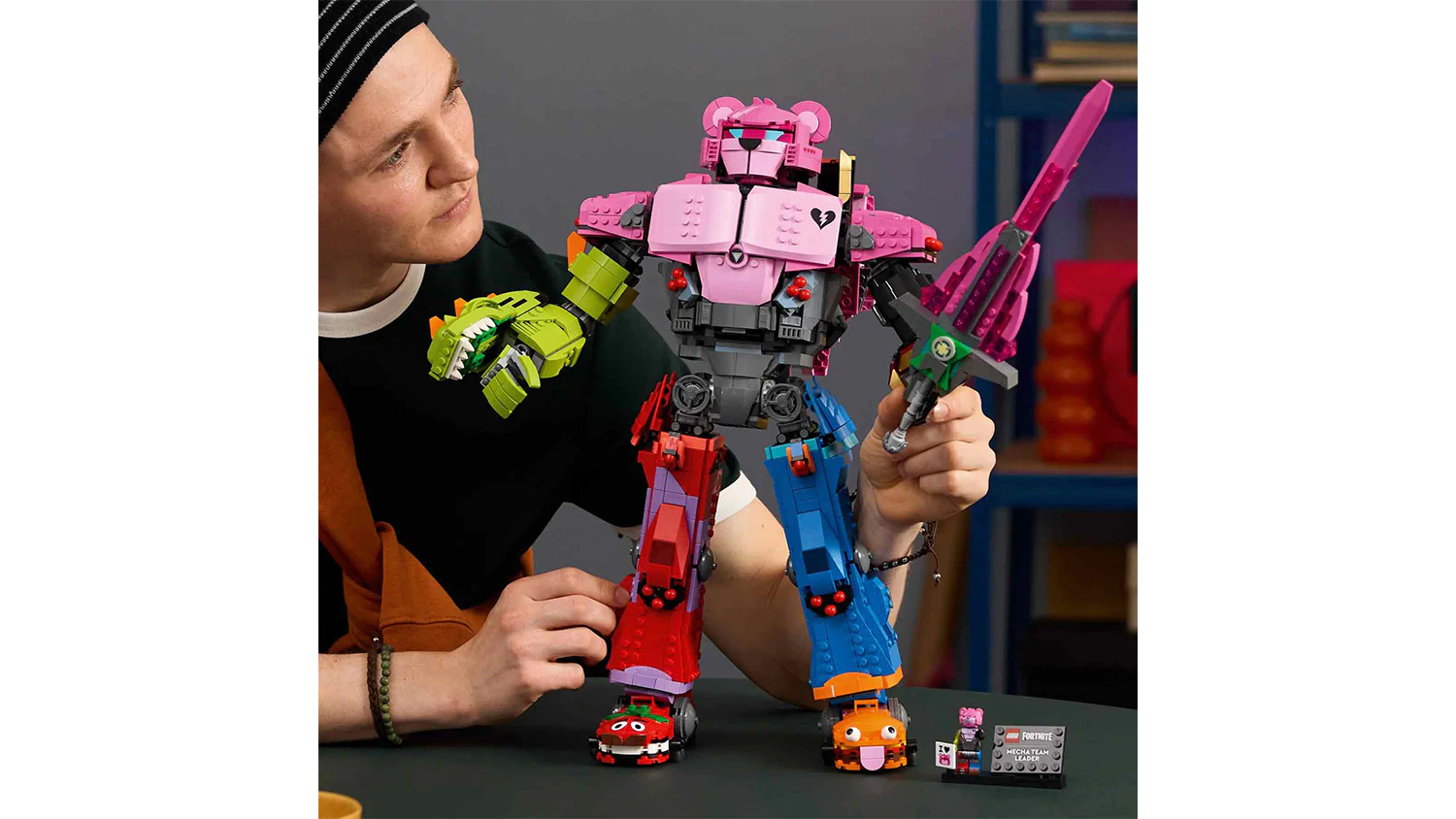 Muž polohuje paži s mečem u modelu robota ze stavebnice LEGO&reg; Fortnite&reg; 77078 Mecha Team Leader